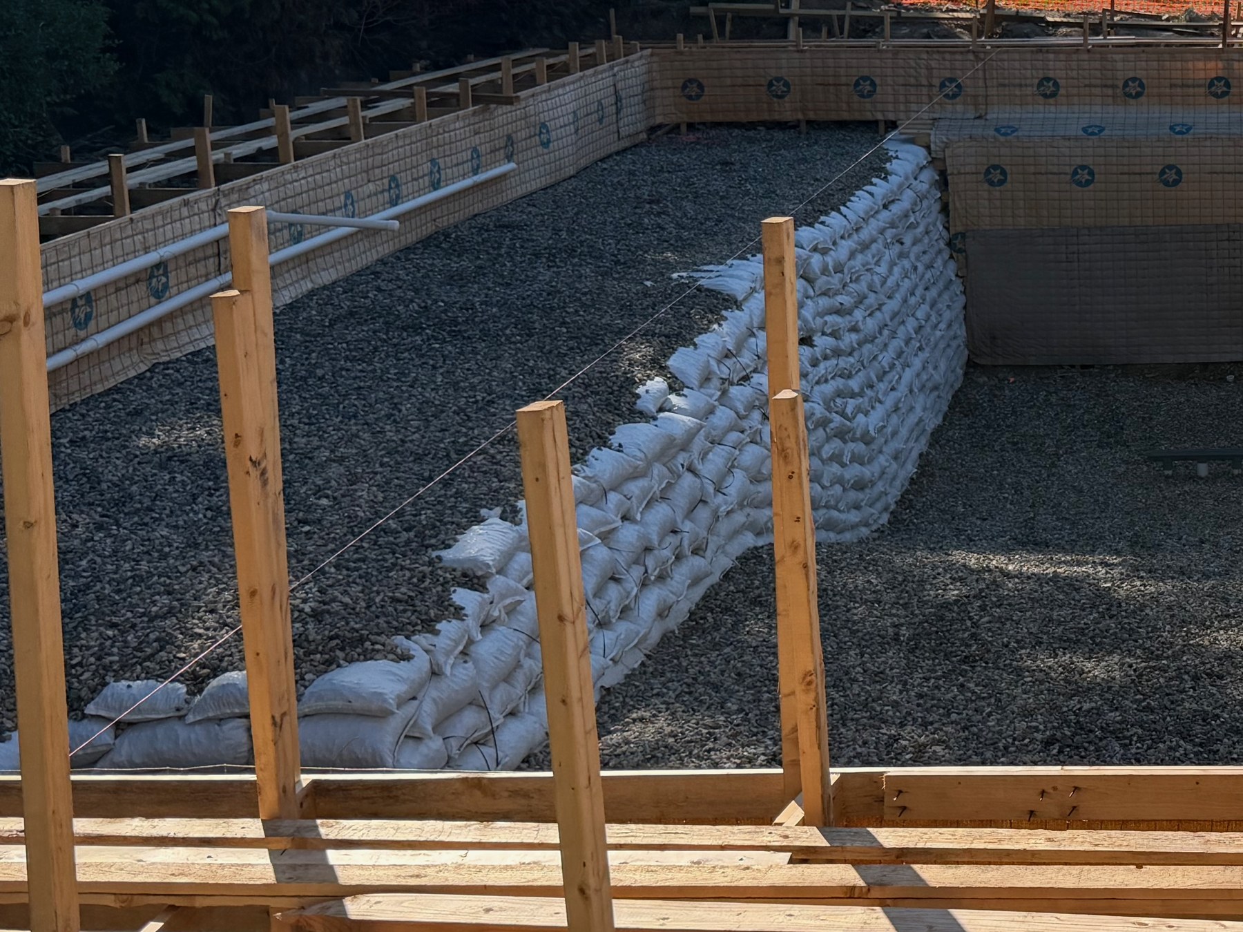The working area of a gunite pool build held to a defined footprint with bracing, retained banks and string lines